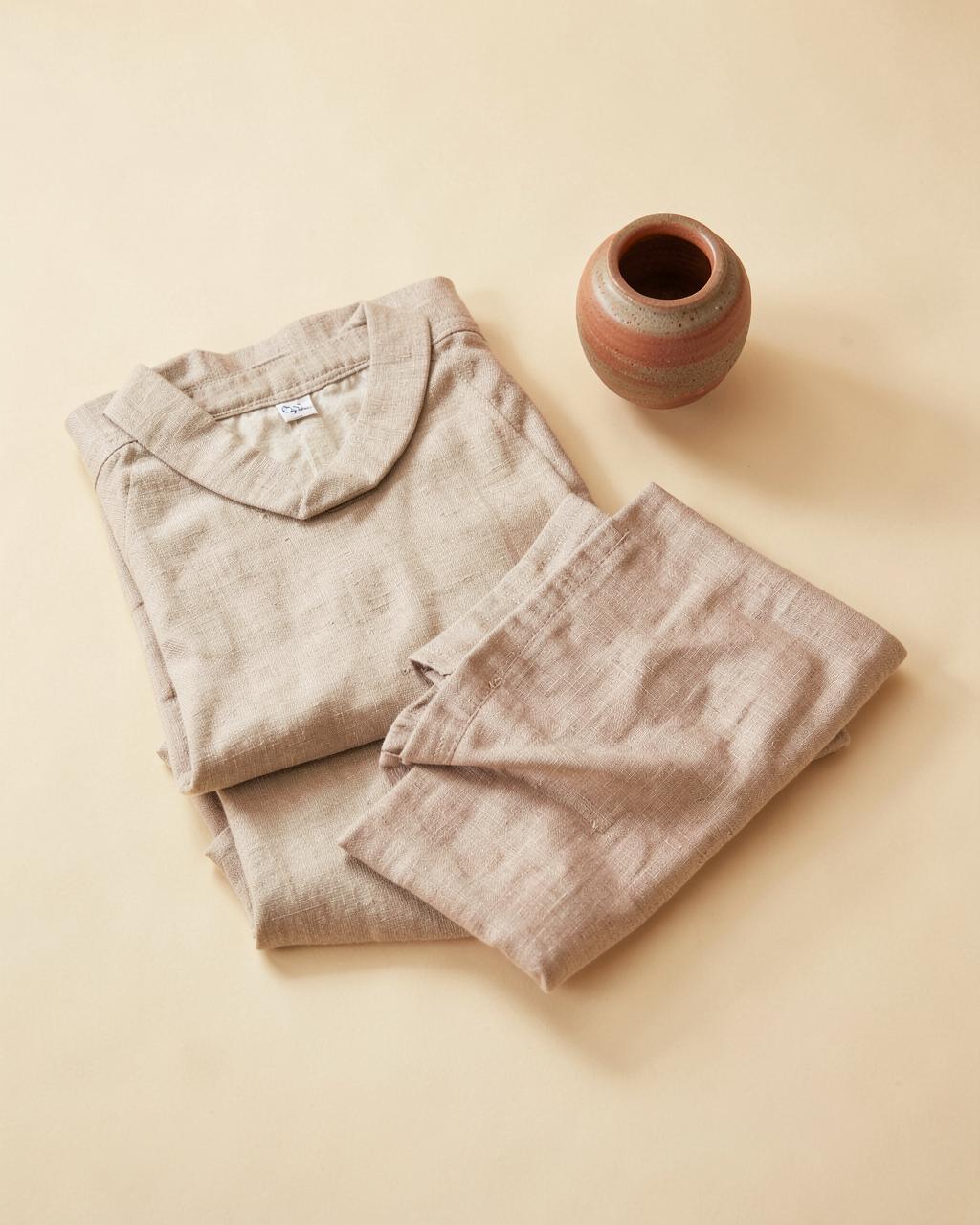 Roupas de linho em tons neutros sobre fundo creme